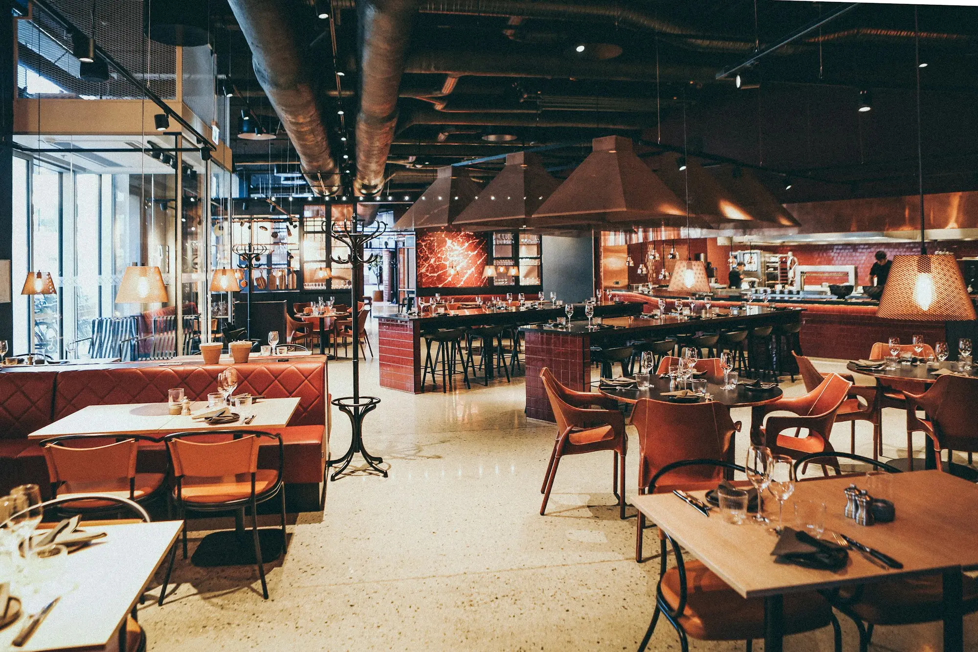 Salon de restaurant cu lumină caldă și mese aranjate